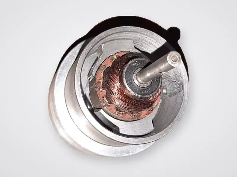 Armature with commutator and bearing inside the motor housing